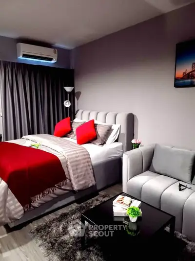 Modern bedroom with stylish decor, featuring a cozy bed, elegant armchair, and sleek black coffee table.