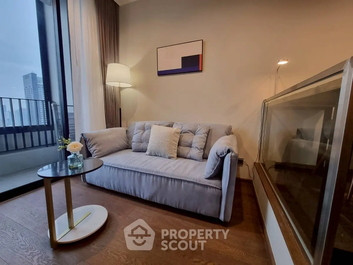 Stylish living room with cozy sofa and modern decor, featuring a city view balcony.