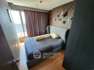 Modern bedroom with stylish decor and large window offering city views