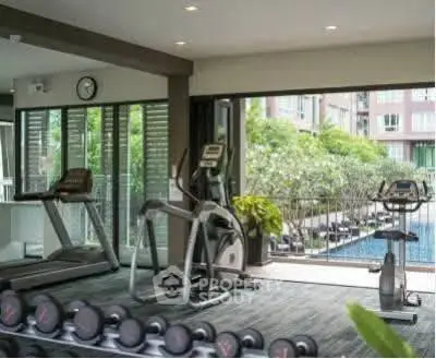 Modern gym with pool view in luxury apartment complex