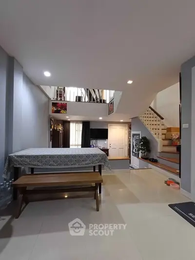 Spacious modern living room with elegant staircase and dining area