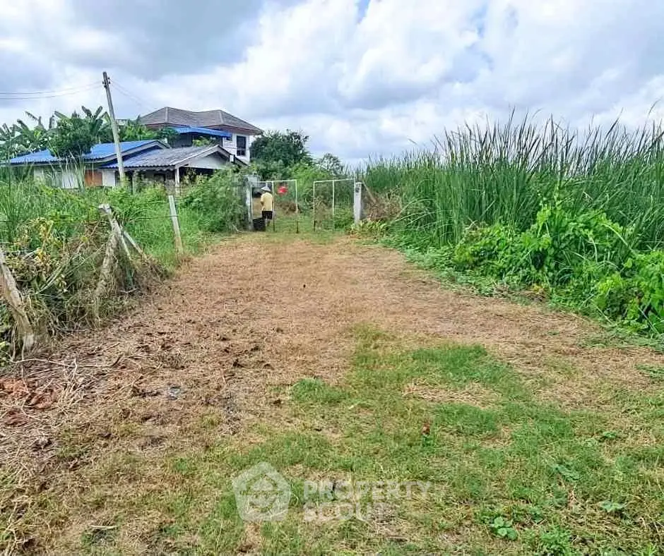 Spacious plot of land with lush greenery and a distant house, perfect for development.