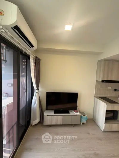 Modern living room with sleek TV setup and balcony view in stylish apartment