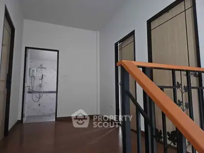 Modern interior hallway with staircase and bathroom view, featuring sleek design and contemporary finishes.