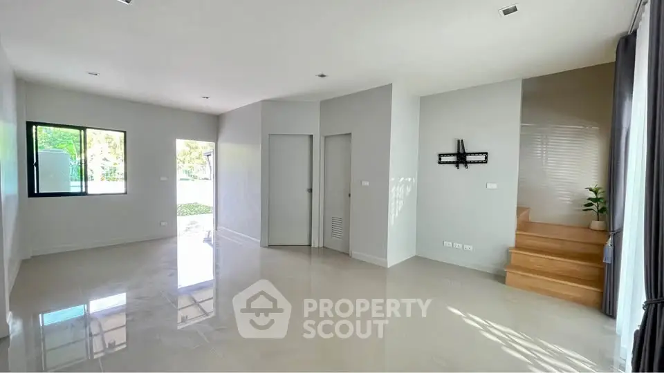 Spacious modern living room with natural light and staircase