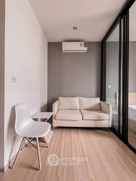 Modern living room with sleek design, featuring a cozy sofa and stylish chair, perfect for urban living.