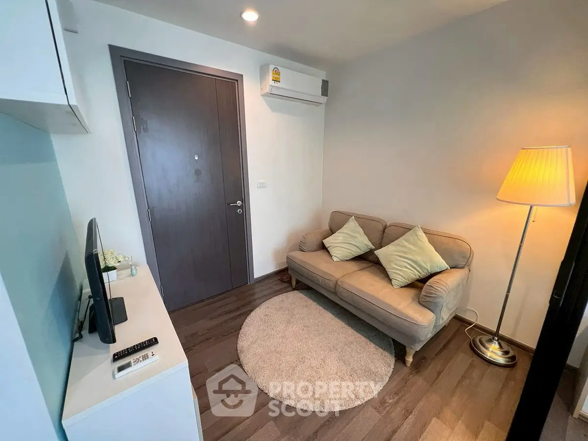 Cozy living room with modern decor, featuring a comfortable sofa, stylish lamp, and sleek flooring.