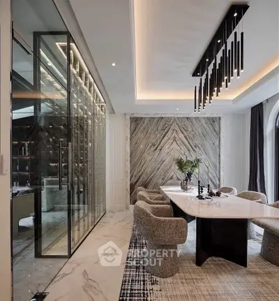 Luxurious dining room with elegant marble table and modern lighting, featuring a glass wine cellar and stylish decor.