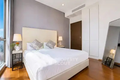 Elegant bedroom with modern decor and large window offering city views