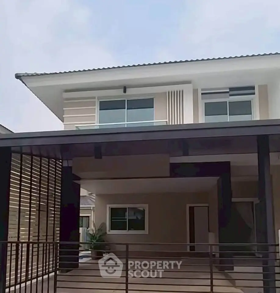Modern two-story house with spacious carport and sleek design.
