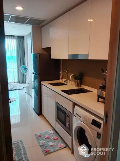 Modern kitchen with sleek appliances and washing machine in stylish apartment