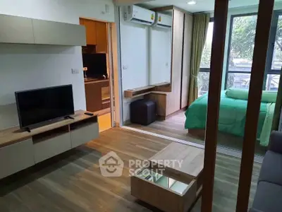 Modern living room with open layout and view into cozy bedroom