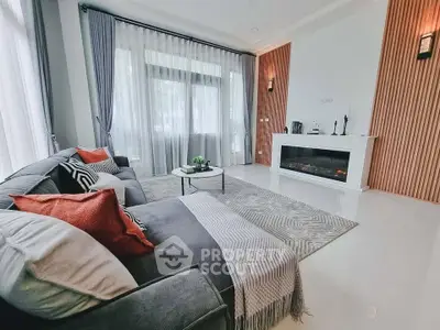 Luxurious living room with elegant decor, cozy fireplace, and large windows for natural light.