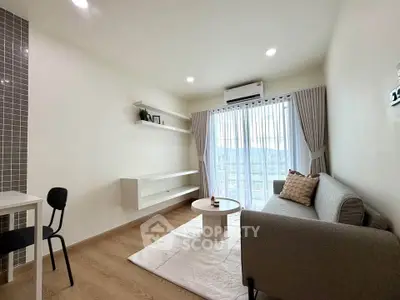 Modern living room with stylish decor, large window, and cozy seating area.
