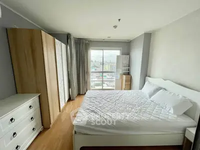 Spacious bedroom with city view, featuring modern furniture and large windows for natural light.