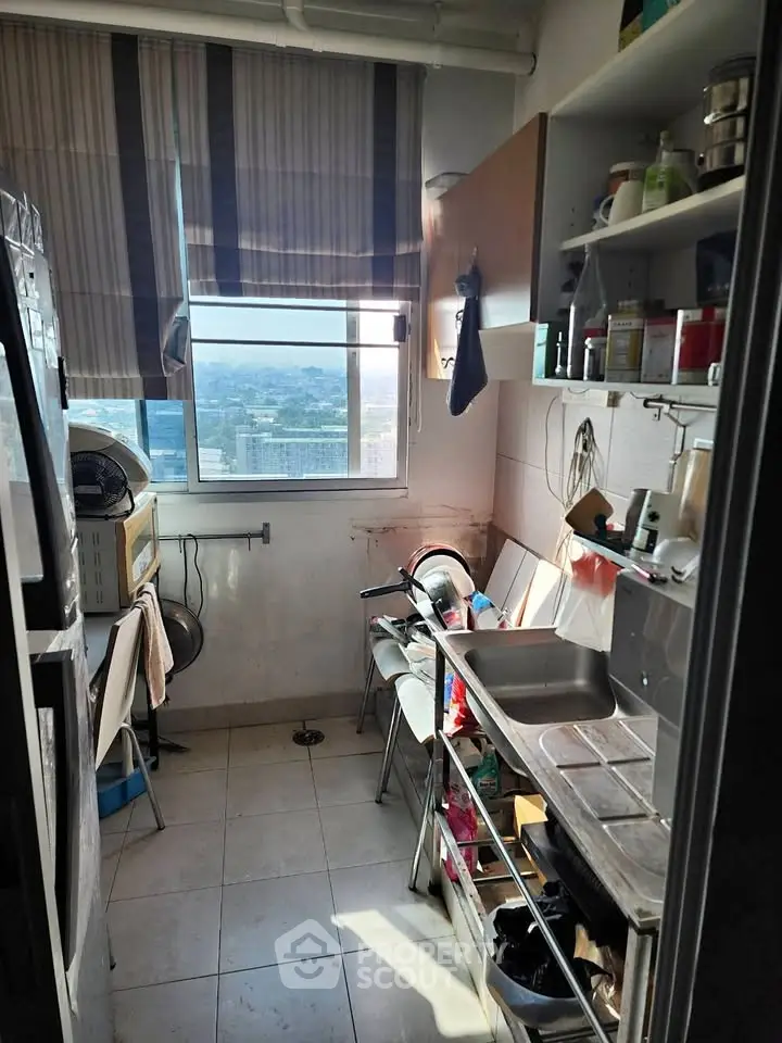 Compact kitchen with city view, featuring open shelving and natural light.