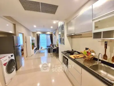 Modern open-layout kitchen with sleek appliances and dining area in a stylish apartment.