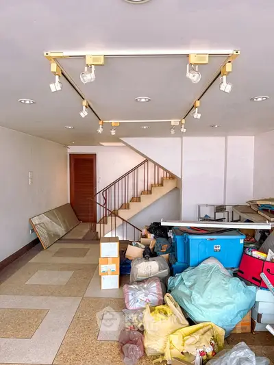 Spacious interior with staircase and storage potential, ideal for renovation.