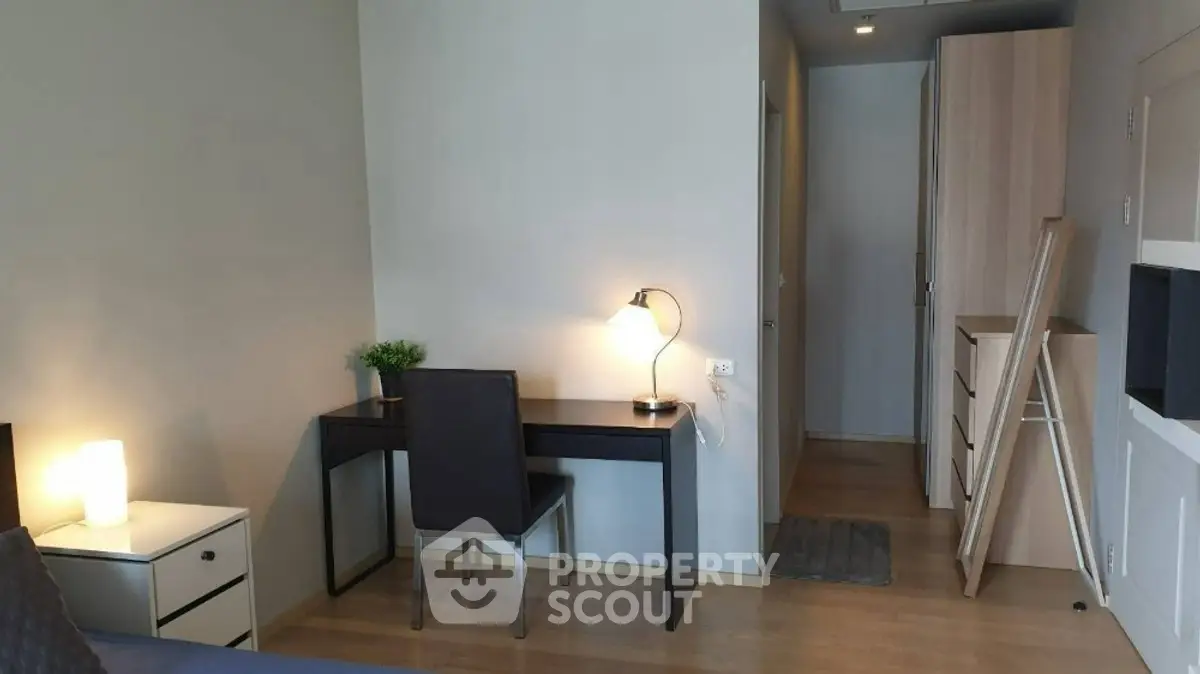 Modern study area with sleek desk and chair in a cozy apartment setting.