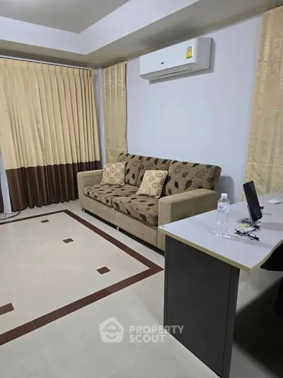 Cozy living room with stylish sofa and air conditioning, perfect for relaxation.
