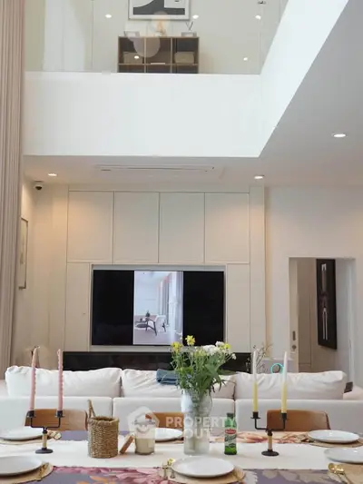 Luxurious living room with high ceiling and elegant dining setup