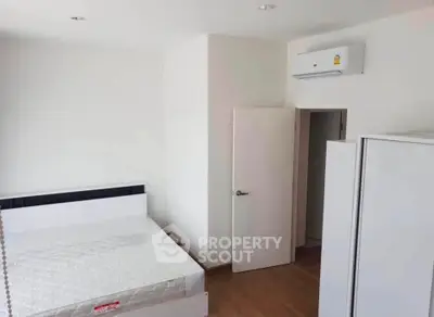Modern minimalist bedroom with air conditioning and white furniture, perfect for a cozy living space.