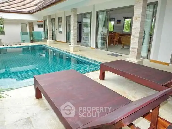 Luxurious villa with private pool and sun loungers, perfect for relaxation.