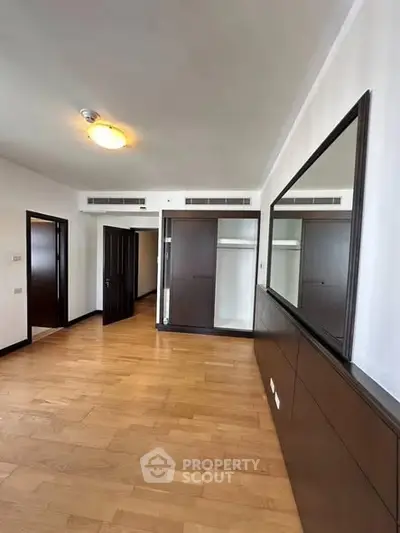 Spacious bedroom with wooden flooring and built-in wardrobe