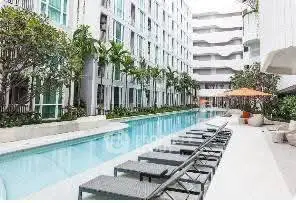 Luxurious apartment complex with modern poolside amenities and stylish outdoor seating.