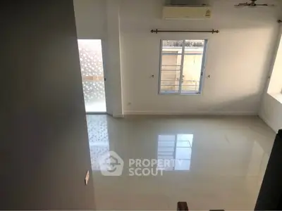 Spacious unfurnished room with large window and air conditioning, perfect for customization.