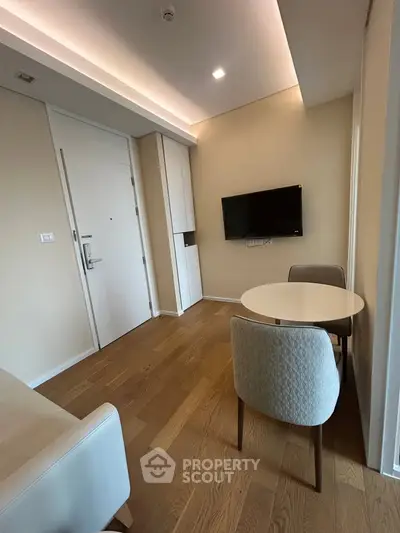 Modern living room with sleek furniture and wall-mounted TV in a stylish apartment.