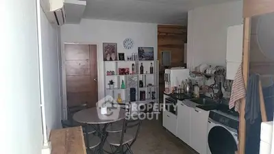 Cozy kitchen space with modern appliances and ample storage, featuring a dining area perfect for intimate meals and gatherings.