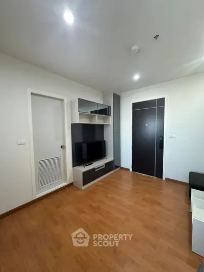Modern living room with sleek TV unit and wooden flooring in a stylish apartment.