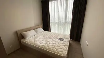 Cozy bedroom with large window and modern furnishings, perfect for relaxation.