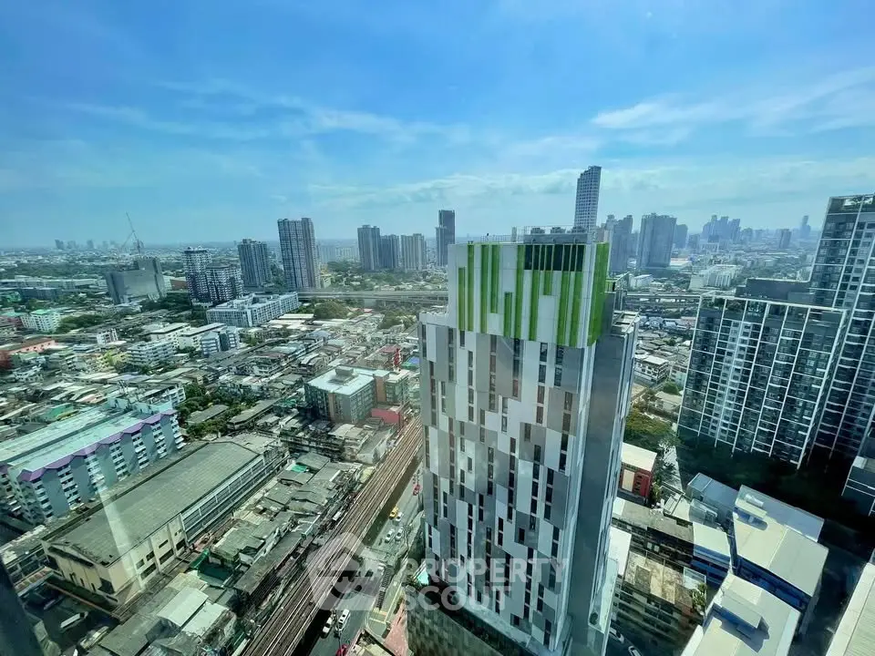 Stunning cityscape view from high-rise building with modern architecture and clear blue sky.