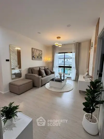 Modern living room with stylish decor and large window view.