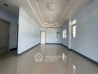 Spacious empty room with glossy tiled floor and modern ceiling design