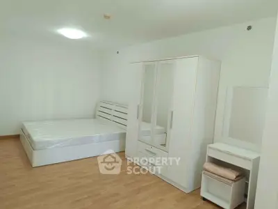 Spacious bedroom with modern white furniture and wooden flooring