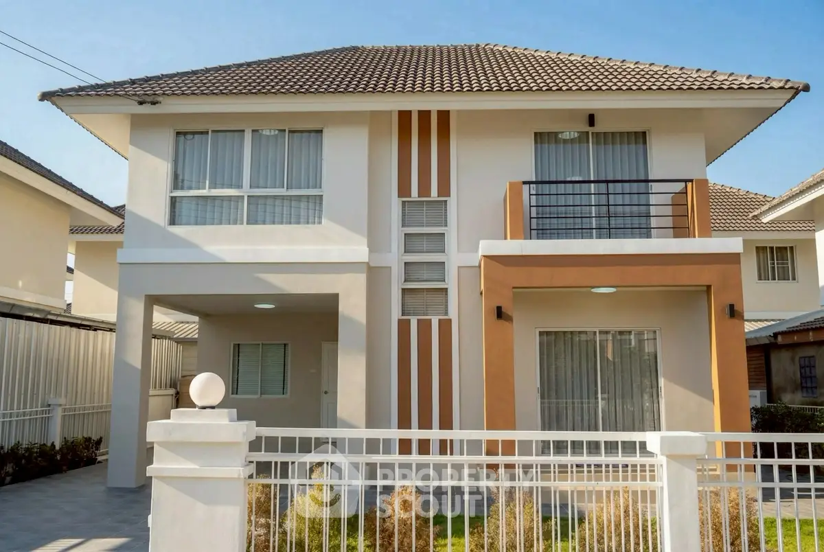 Modern two-story house with balcony and stylish facade in sunny neighborhood.