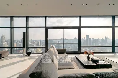 Luxurious living room with panoramic city skyline view and modern furnishings.