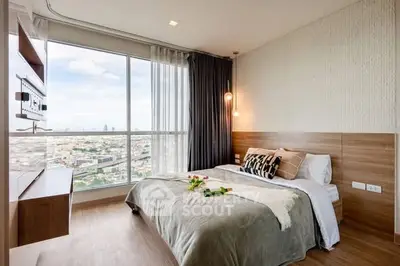 Modern bedroom with large window offering stunning city view and stylish decor.