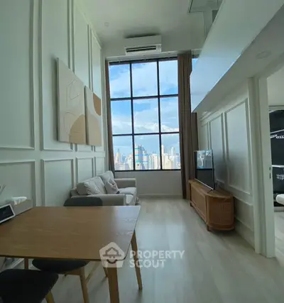 Stunning high-ceiling living room with city view, modern decor, and natural light.