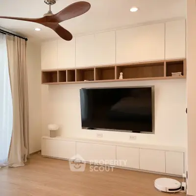 Modern living room with sleek TV setup and stylish ceiling fan