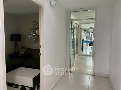 Modern hallway with sleek design leading to a cozy living area.