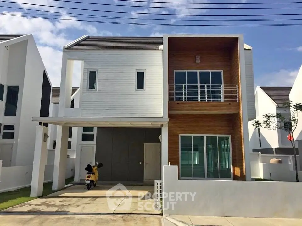 Modern two-story house with unique architectural design and spacious driveway.