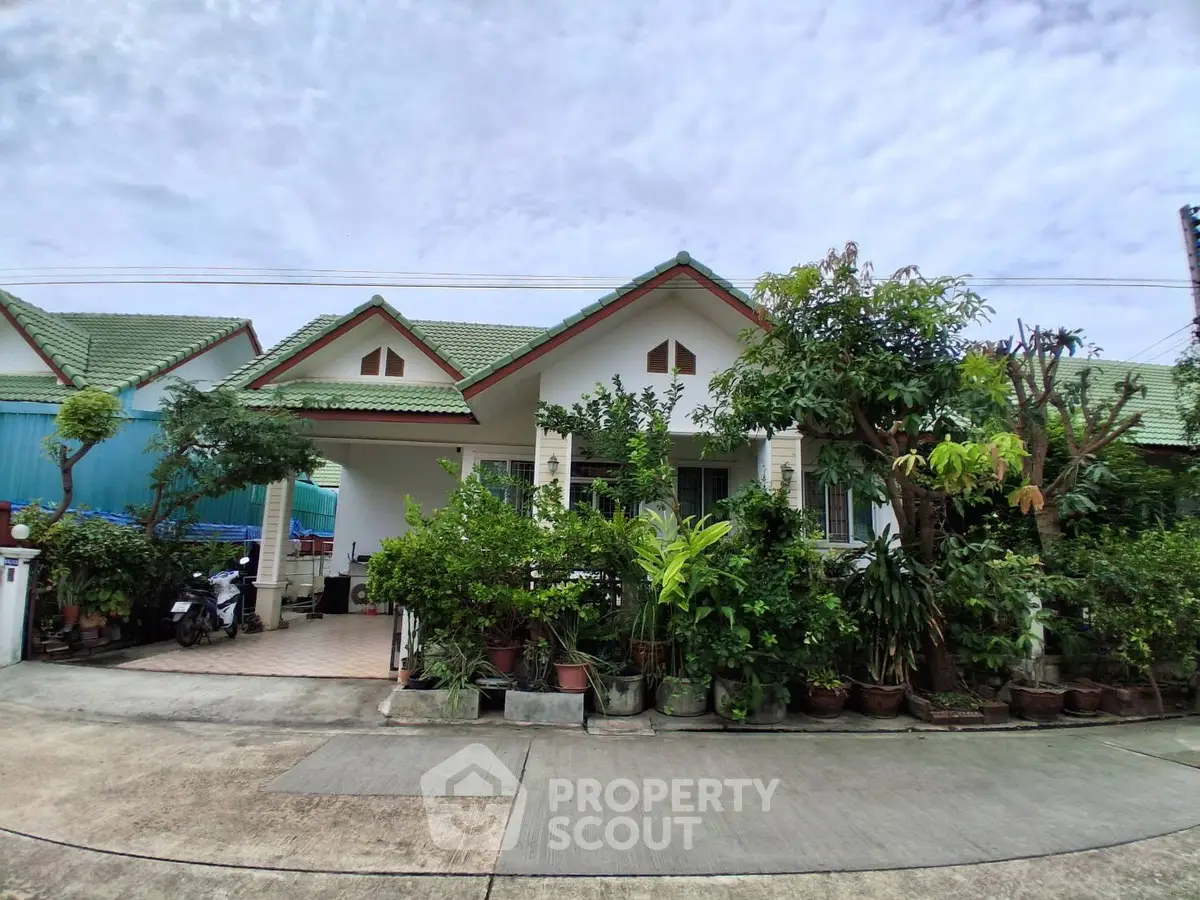 Charming single-story home with lush garden and green roof, perfect for serene living.