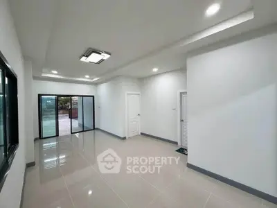 Spacious modern living room with sleek tile flooring and large windows.