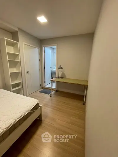 Cozy bedroom with wooden flooring and minimalist furniture