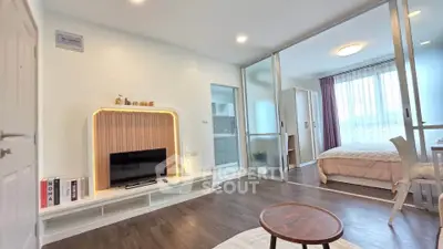 Modern open-plan living room with stylish decor and cozy bedroom view