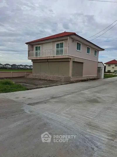Charming two-story house with red roof and spacious balcony in a serene neighborhood.